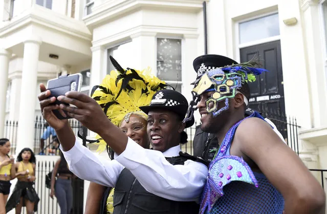 A police offer takes a selfie with performers during the Notting Hill Carnival on August 29, 2016 in London, England. The Notting Hill Carnival has taken place every year since 1966 in Notting Hill in north-west London and is one of the largest street festivals in Europe with more than a million people expected over two days. (Photo by Ben A. Pruchnie/Getty Images)