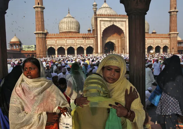 Muslim women greet each other after offering Eid al-Adha prayers at the Jama Masjid (Grand Mosque) in the old quarters of Delhi October 6, 2014. Muslims around the world celebrate Eid al-Adha by the sacrificial killing of sheep, goats, cows and camels to commemorate Prophet Abraham's willingness to sacrifice his son Ismail on God's command. (Photo by Ahmad Masood/Reuters)