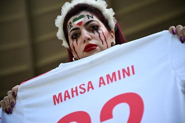 An Iran fan holds a shirt in protest with the name Mahsa Amini who died under Police custody during the FIFA World Cup Qatar 2022 Group B match between Wales and IR Iran at Ahmad Bin Ali Stadium on November 25, 2022 in Doha, Qatar. (Photo by Dylan Martinez/Reuters)