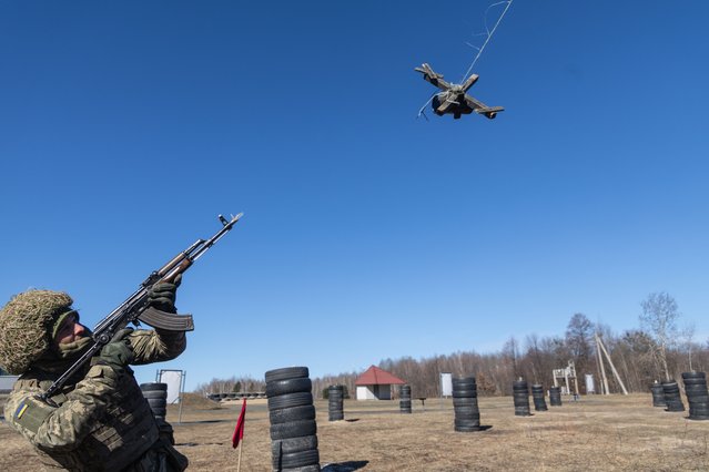 Mobilized Ukrainian Air Assault Forces soldiers practice aiming and shooting at a moving wooden target simulating a drone during basic military training. (Photo by Andriy Dubchak/Frontliner/Getty Images)