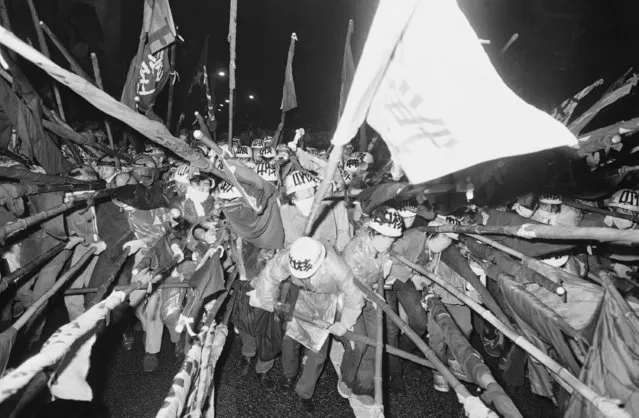 Armed with bamboo poles and protected with hard hats, a massed group of Japanese students surge forward to begin a demonstration in Tokyo on September 30, 1971.  Their protest was against terms for the return of Okinawa from U.S. to Japanese control. (Photo by AP Photo)