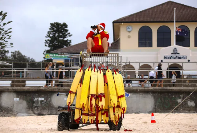 A surf lifesaver wearing a Christmas hat uses binoculours to watch swimmers on Christmas Day at Sydney's Bondi Beach in Australia, December 25, 2017.. (Photo by David Gray/Reuters)