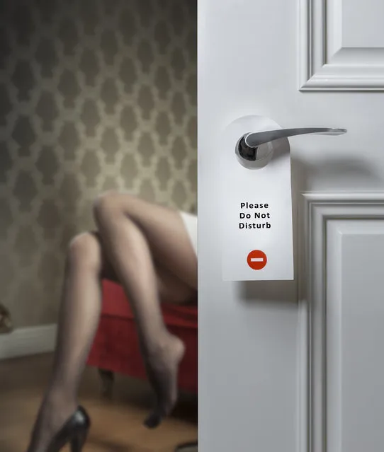 Hotel door with do not disturb icon and sеxy female legs on the background. (Photo by nexus 7/Rex Features/Shutterstock)