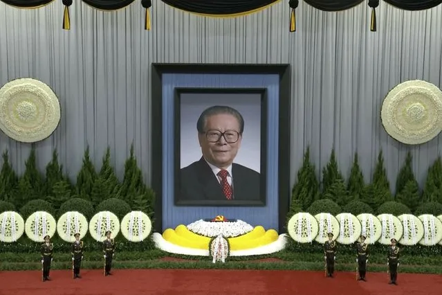In this image taken from video footage run by China's CCTV, honor guard members stand near a giant portrait of late former Chinese President Jiang Zemin during a formal memorial held at the Great Hall of the People in Beijing on Tuesday, December 6, 2022. (Photo by CCTV via AP Photo)