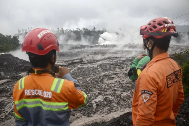 Rescuers monitor the flow of volcanic materials from the eruption of Mount Semeru, in Lumajang, East Java, Indonesia, Sunday, December 4, 2022. Indonesia's highest volcano on its most densely populated island released searing gas clouds and rivers of lava Sunday in its latest eruption. (Photo by Hendra Permana/AP Photo)