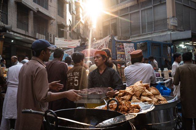 Pakistani vendors wait for customers as they prepare fried foods used to break the Ramadan fast at a stall on March 24, 2025 in Lahore, Pakistan. Ramadan is a sacred month in the Islamic calendar, observed by Muslims worldwide as a period of fasting, spiritual reflection, and charitable giving. (Photo by Rebecca Conway/Getty Images)