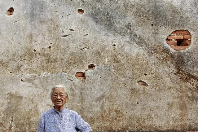 An elderly woman poses in front of a bullet-riddled wall of her house in the village of Guningtou in Kinmen, Taiwan, September 7, 2015. (Photo by Pichi Chuang/Reuters)