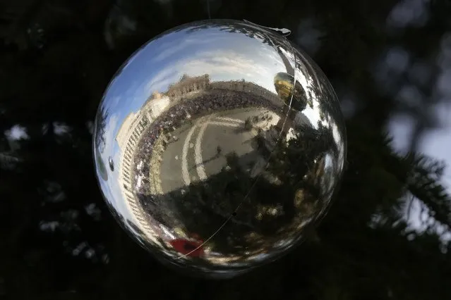 St. Peter's Basilica is reflected in a ball adorning St. Peter's Square Christmas tree before the Angelus noon prayer with Pope Francis, at the Vatican, Sunday, January 1, 2023. (Photo by Andrew Medichini/AP Photo)