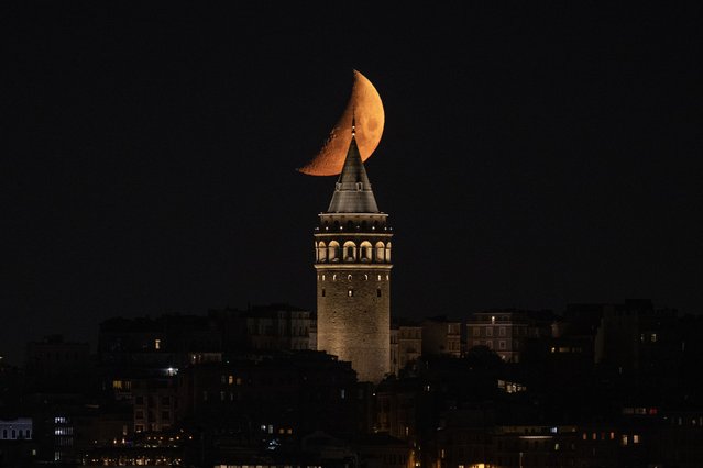 Half moon is seen with Galata Tower during evening in Istanbul, Turkiye on June 1, 2025. (Photo by Muhammed Abdullah Kurtar/Anadolu via Getty Images)