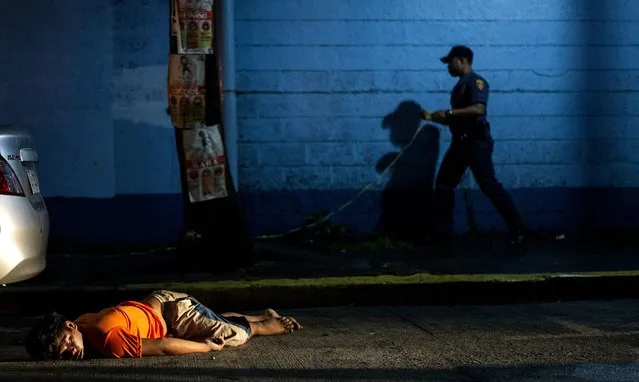 In this photograph taken on July 23, 2016, the body of a man, shot dead by unidentified gunmen, lies on the ground in Manila. The Philippine government on August 19, 2016, criticised as “baseless and reckless” a UN statement that President Rodrigo Duterte's bloody war on drugs amounted to a crime under international law. (Photo by Noel Celis/AFP Photo)
