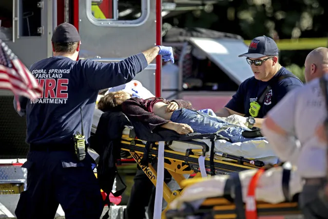 Medical personnel tend to a victim following a shooting at Marjory Stoneman Douglas High School in Parkland, Fla., on Wednesday, February 14, 2018. (Photo by John McCall/South Florida Sun-Sentinel via AP Photo)
