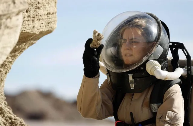 Csilla Orgel, a geologist with Crew 125 EuroMoonMars B mission, collects geologic samples for study at the Mars Desert Research Station (MDRS) outside Hanksville in the Utah desert March 2, 2013. The MDRS aims to investigate the feasibility of a human exploration of Mars and uses the Utah desert's Mars-like terrain to simulate working conditions on the red planet. Scientists, students and enthusiasts work together developing field tactics and studying the terrain. All outdoor exploration is done wearing simulated spacesuits and carrying air supply packs and crews live together in a small communication base with limited amounts of electricity, food, oxygen and water. Everything needed to survive must be produced, fixed and replaced on site. (Photo by Jim Urquhart/Reuters)