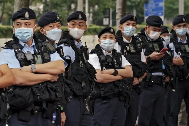 Policemen wearing face masks stand guard outside the West Kowloon Magistrates' Courts ahead of the national security trail for the pro-democracy activists in Hong Kong, Monday February 6, 2023. (Photo by Anthony Kwan/AP Photo)