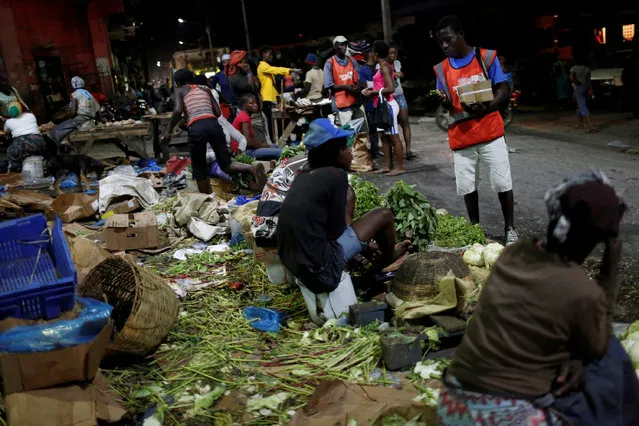 Vendors sell their goods at a street market while Hurricane Matthew approaches in Port-au-Prince, Haiti, October 2, 2016. (Photo by Carlos Garcia Rawlins/Reuters)