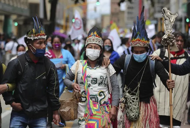 A group of Indigenous march during a national strike in Bogota, Colombia, Wednesday, October 21, 2020. Workers' unions, university students, human rights defenders, and Indigenous communities have gathered for a day of protest in conjunction with a national strike across Colombia. The protest is against the assassinations of social leaders, in defense of the right to protest and to demand advances in health, income and employment. (Photo by Fernando Vergara/AP Photo)