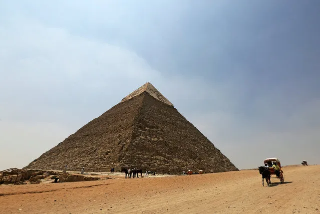 Tourists ride horse carts and camels at the Giza pyramids area on the outskirts of Cairo, Egypt, August 31, 2016. (Photo by Mohamed Abd El Ghany/Reuters)