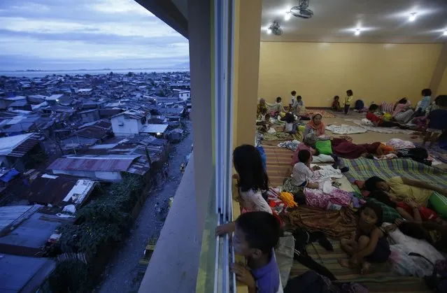 Children look out of a window at an evacuation centre for the coastal community, to shelter from typhoon Hagupit, near Manila, December 8, 2014. (Photo by Cheryl Gagalac/Reuters)