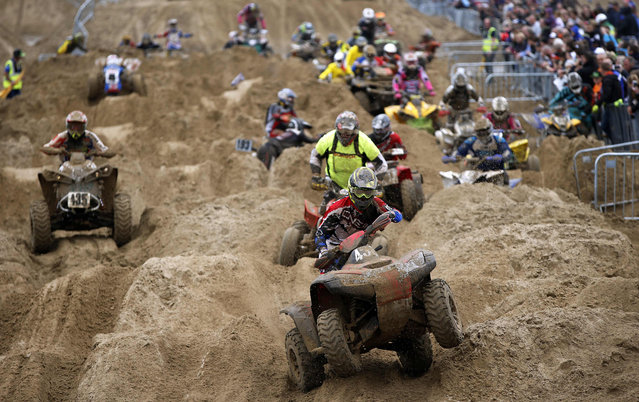 A quad rider wheelies over the bumps during the Adult Quad and Sidecar at the 2016 HydroGarden Weston Beach Race in Weston- super- Mare, south west England, on October 8, 2016. Beach racing is an offshoot of enduro and motocross racing. Riders on solo motorcycles and quad bikes compete on a course marked out on a beach, with man- made jumps and sand dunes being constructed to make the course tougher. (Photo by Adrian Dennis/AFP Photo)