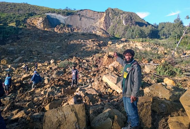 People gather at the site of a landslide in Maip Mulitaka in Papua New Guinea's Enga Province on May 24, 2024. Local officials and aid groups said a massive landslide struck a village in Papua New Guinea's highlands on May 24, with many feared dead. (Photo by AFP Photo/Stringer)
