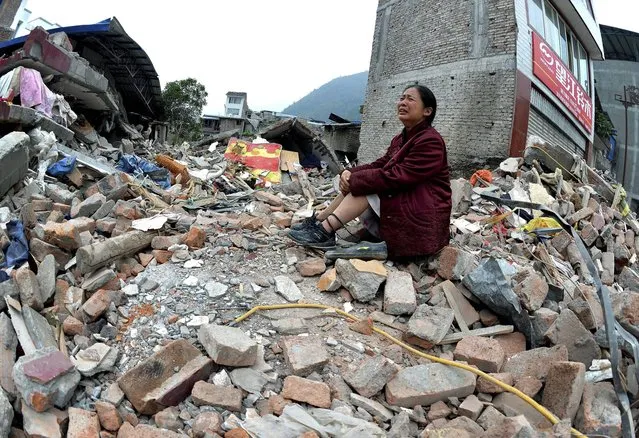 A woman whose relatives were killed in Saturday's earthquake cries while sitting on a pile of rubble in Lingguan township in Baoxing county of southwest China's Sichuan province on Sunday, April 21, 2013. Saturday's earthquake in Sichuan province killed at least 186 people, injured more than 11,000 and left nearly two dozen missing, mostly in the rural communities around Ya'an city, along the same fault line where a devastating quake to the north killed more than 90,000 people in Sichuan and neighboring areas five years ago in one of China's worst natural disasters. (Photo by AP Photo)