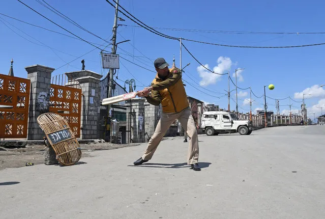 An Indian police officer plays cricket on a deserted road, during a strike called by Kashmiri separatists, against the recent killings in Kashmir, in downtown Srinagar April 12, 2018. (Photo by Danish Ismail/Reuters)