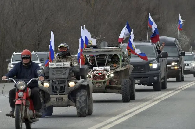 Members of the Russian biker group Nochniye Volki (the Night Wolves) drive with Russian national flags toward Sevastopol attending a motor rally marking the ninth anniversary of Crimea annexation from Ukraine, Crimea, Saturday, March 18, 2023. (Photo by AP Photo/Stringer)