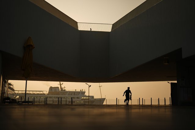 A commuter runs towards Kabatas ferry terminal next to the Bosphorus strait, in Istanbul, Turkey, November 4, 2025. (Photo by Francisco Seco/AP Photo)