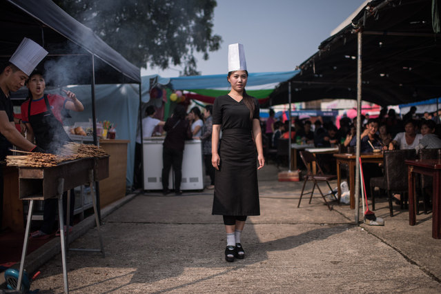 In a photo taken on September 25, 2017 barbeque chef Ryu Gyong Hui (23) poses for a portrait at her stall outside a trade fair in Pyongyang. (Photo by Ed Jones/AFP Photo)