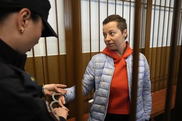 Theater director Zhenya Berkovich stands in a cage in a courtroom prior to a hearing in a court in Moscow, Russia, Friday, May 5, 2023. Theater director Zhenya Berkovich and playwright Svetlana Petriychuk were detained on Thursday on the charge of justifying terrorism because of their play “Finist, the Brave Falcon”. The play is about women who were lured into marriage by representatives of radical Islam, went to live with them in Syria and faced prosecution upon returning to Russia. Berkovich and Petriychuk have maintained their innocence. (Photo by Alexander Zemlianichenko/AP Photo)