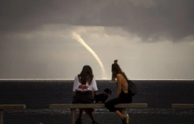 People look at a funnel cloud formed near the beach in Barcelona, Spain, Monday, September 21, 2020. (Photo by Emilio Morenatti/AP Photo)