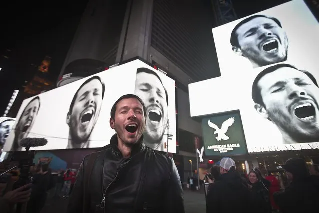 Artist Sebastian Errazuriz yawns, posing for photos as his video art installation “A Pause in the City That Never Sleeps” is projected on screens in Times Square in Manhattan, New York January 17, 2015. The display is part of “Midnight Moment”, a monthly presentation by The Times Square Advertising Coalition and Times Square Arts. (Photo by Carlo Allegri/Reuters)