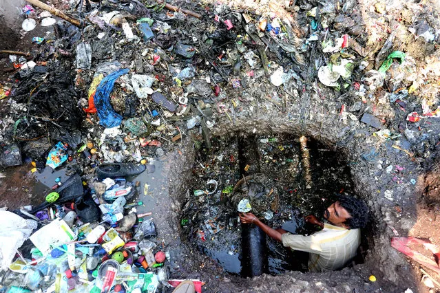 A worker cleans a sewage pipe in Bhopal, India, 02 December 2015. Bhopal sees the 31st anniversary of a gas leak at the then Union Carbide Corporation plant in the city overnight 03 December 1984, which killed at least 15,000 people in what is considered the world's worst industrial accident. (Photo by Sanjeev Gupta/EPA)
