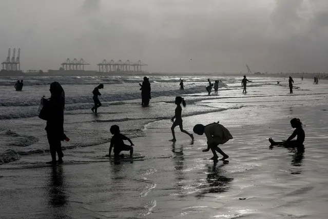 People are silhouetted as they cool off during a hot and humid day, along Clifton beach in Karachi, Pakistan on June 1, 2023. (Photo by Akhtar Soomro/Reuters)