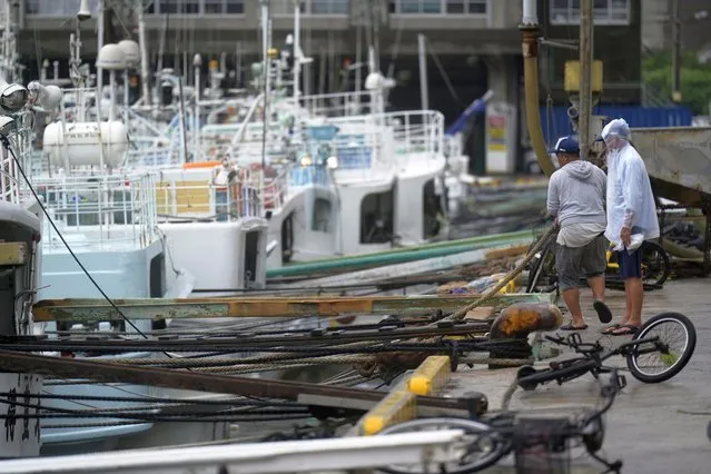 Fishermen make a routine check on their boat docked at the Tomari fishery port in Naha in the main Okinawa island, southern Japan, Thursday, June 1, 2023, after they have prepared some protections against a tropical storm nearing the Okinawa islands. (Photo by Hiro Komae/AP Photo)