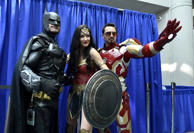 Armando Abarca, dressed as Batman, left, and Jessica Rose Davis, dressed as Wonder Woman, center, of Los Angeles, and Guillermo Gonzalez, of Sacramento, Calif., dressed as Iron Man, attend day one of Comic-Con International on Thursday, July 19, 2018, in San Diego.(Photo by Chris Pizzello/Invision/AP Photo)