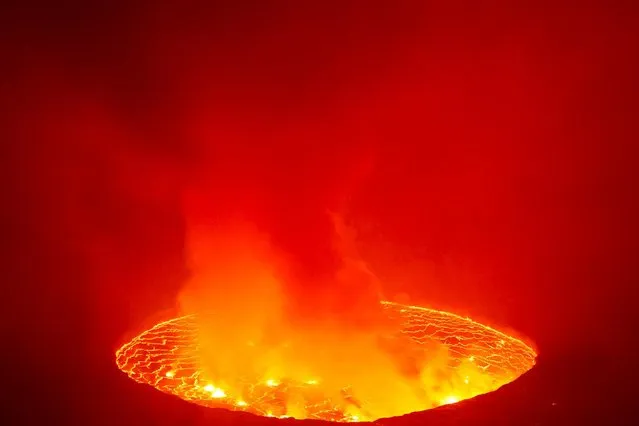 Lava lake lights up the night sky on Mount Nyiragongo volcano, inside the Virunga National Park, near Goma, in the eastern Democratic Republic of Congo on March 2021. Analysts say the crater of Mount Nyiragongo in the eastern Democratic Republic of Congo has refilled with magma, raising the crater floor and fears of an even bigger disaster if an earthquake were to cause a fracture in the flank of the volcano. (Photo by Hereward Holland/Reuters)