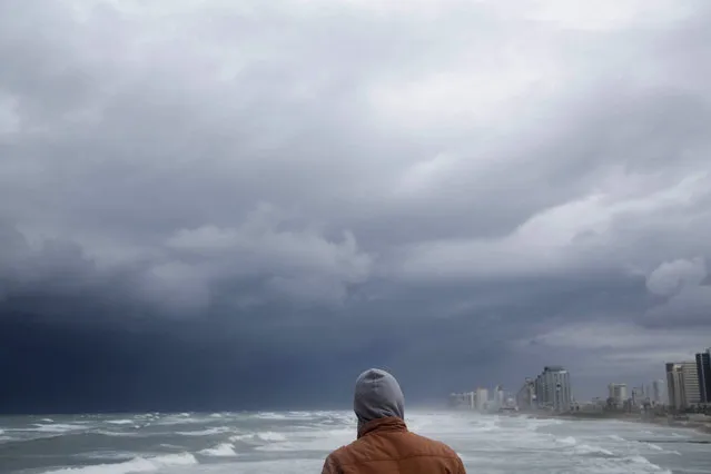 A man overlooks he high waves in the Mediterranean Sea in Tel Aviv, Israel, Wednesday, January 7, 2015 during a heavy winter storm sweeping through the Middle East.(Photo by Oded Balilty/AP Photo)