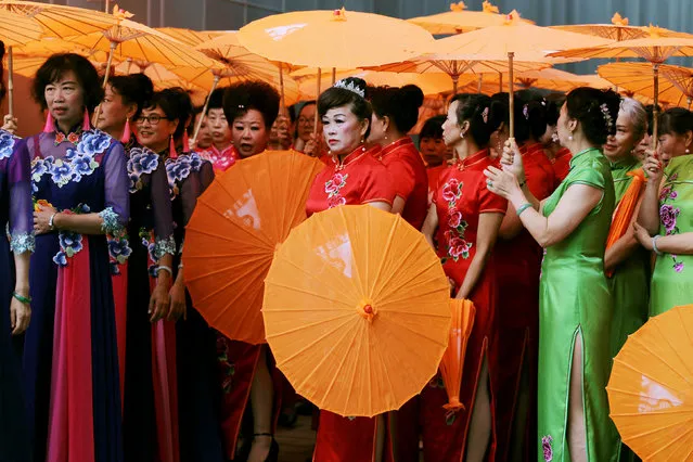 Performers wearing cheongsams wait to perform at a cultural industry expo in Kunming, Yunnan province, China on August 9, 2018. (Photo by Wong Campion/Reuters)