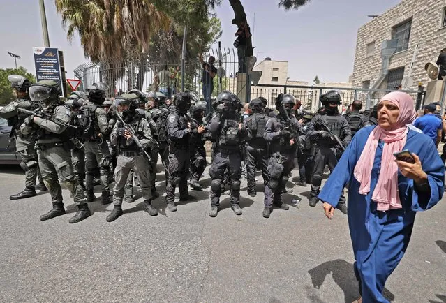 Israeli security forces stand guard in front of the hospital where Al-Jazeera journalist Shireen Abu Akle is kept, before her casket is transported to a church and then her resting place, in Jerusalem, on May 13, 2022. Abu Akleh, who was shot dead on May 11, 2022 while covering a raid in the Israeli-occupied West Bank, was among Arab media's most prominent figures and widely hailed for her bravery and professionalism. (Photo by Ahmad Gharabli/AFP Photo)