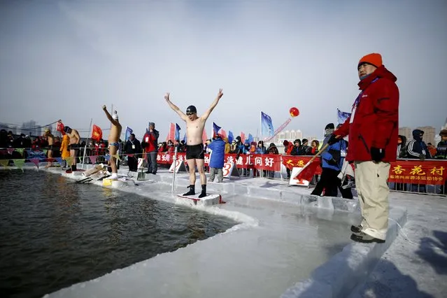 Swimmers wave in a pool carved from thick ice covering the Songhua River during the Harbin Ice Swimming Competition in the northern city of Harbin, Heilongjiang province, January 5, 2016. (Photo by Aly Song/Reuters)