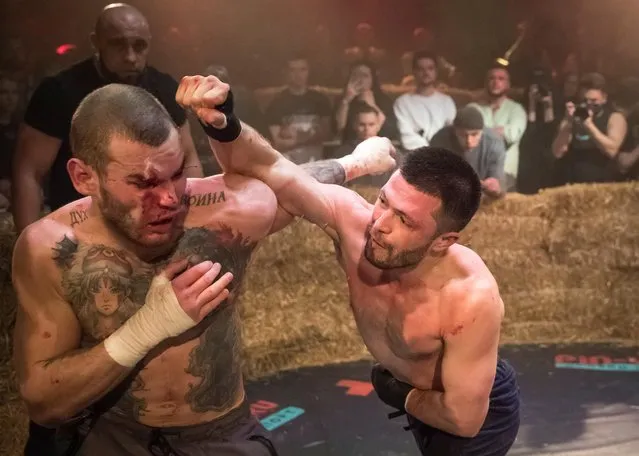 Danik Vesnenok and Danila Utenkov fight during the “Top Dog” bare-knuckle boxing tournament in Moscow, Russia on April 16, 2021. The tournament began broadcasting fights in parking lots in early 2020, but now rents out a Moscow sports arena for bare-knuckle bouts that are viewed online by millions. The most popular fight yet has been viewed over 13 million times on YouTube. The organizers attribute the sport's popularity to pent-up aggression because of COVID-19 restrictions and frustrations over the economy. (Photo by Shamil Zhumatov/Reuters)