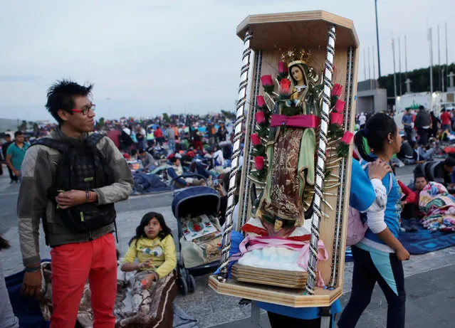 A pilgrim carries a statue of the Virgin of Guadalupe as he arrives at the Basilica of Guadalupe during the annual pilgrimage in honor of the Virgin of Gudalupe, patron saint of Mexican Catholics, in Mexico City, Mexico December 11, 2016. (Photo by Henry Romero/Reuters)