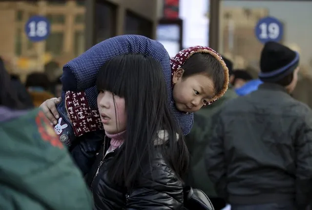 Wei Yangkun, 2.5 years old, is carried by his mother as they leave Beijing Railway Station for their hometown Xinyang of Henan province, in Beijing, China, January 25, 2016. According to traffic police, over 2.9 billion trips will be made around China during the 40-day Spring Festival travel rush, which started on January 24. (Photo by Jason Lee/Reuters)