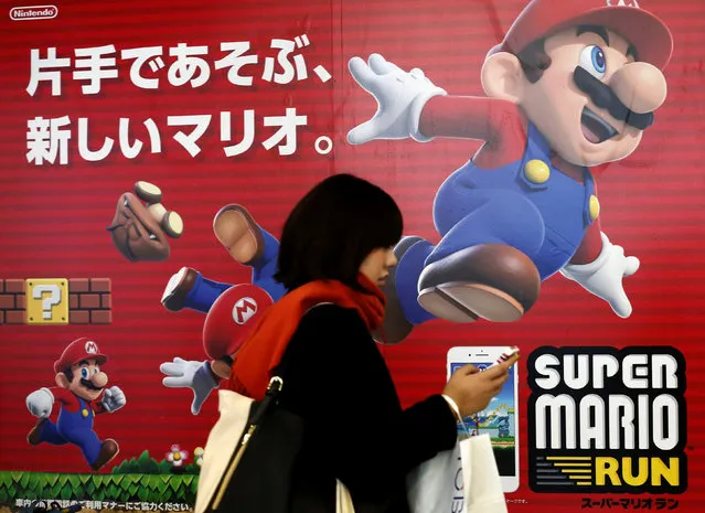 A woman using a smartphone walks past Nintendo's “Super Mario Run” game advertisement board at a subway station in Tokyo, Japan, December 21, 2016. Mario ran right to the top of the download charts this week, with Nintendo's first-ever smartphone game, Super Mario Run, hitting 40 million downloads in its first four days. That makes it the fastest-selling iOS game in the history of the App Store. Still, things aren't completely peachy in the Mushroom Kingdom. App analyst Sensor Tower says that the game netted as much as $21 million in its first four days, but pointed out that Nintendo's stock simultaneously hit a one-month low. Sensor Tower analyst Spencer Gabriel points out that only about eight percent of users who download Super Mario Run and play its first three levels go on to spend the requisite $10 to unlock the rest of the game. (Photo by Kim Kyung-Hoon/Reuters)