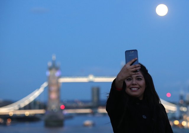 A woman takes a selfie as the supermoon rises over Tower Bridge in London, in this August 10, 2014 file photo. (Photo by Paul Hackett/Reuters)