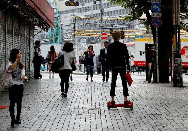 A man rides a hoverboard on a street in a shopping district in Tokyo, Japan, September 29, 2016. (Photo by Toru Hanai/Reuters)