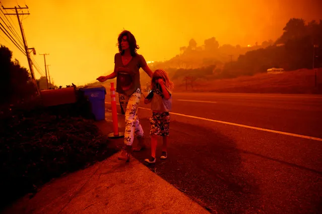 Gabi and Jonah Frank walk on the Pacific Coast Highway as the Woolsey Fire threatens their home in Malibu, California, November 9, 2018. (Photo by Eric Thayer/Reuters)