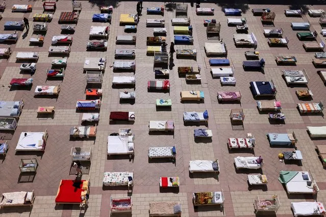 People look at mattresses and beds, part of an installation “Empty Beds” initiated by survivors of Kibbutz Nir Oz and the families of hostages held in Gaza, following a deadly infiltration into southern Israel by Hamas gunmen, at a public square in Jerusalem on October 30, 2023. (Photo by Ronen Zvulun/Reuters)