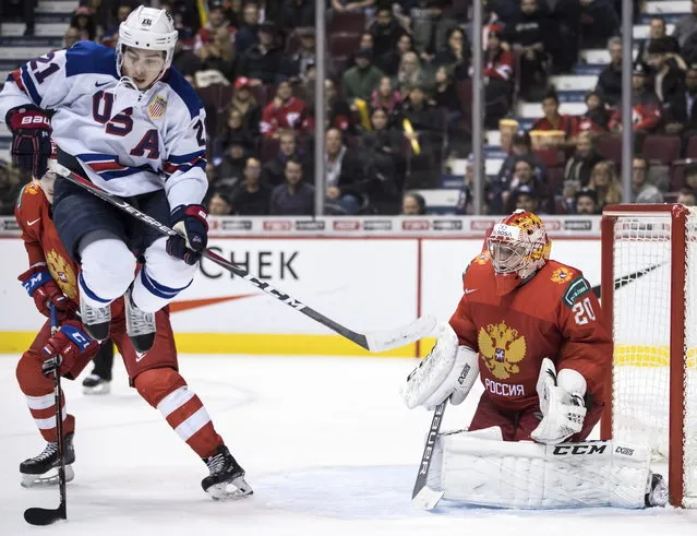 United States' Noah Cates (21) jumps in front of Russia goalie Pyotr Kochetkov (20) during second-period IIHF world junior semifinal hockey action in Vancouver, British Columbia, Friday, January 4, 2019. (Photo by Darryl Dyck/The Canadian Press via AP Photo)