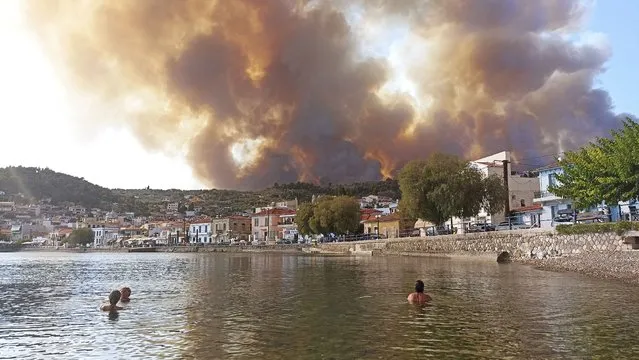 Flames burn on the mountain near Limni village on the island of Evia, about 160 kilometers (100 miles) north of Athens, Greece, Tuesday, August 3, 2021. Greece Tuesday grappled with the worst heatwave in decades that strained the national power supply and fueled wildfires near Athens and elsewhere in southern Greece. As the heat wave scorching the eastern Mediterranean intensified, temperatures reached 42 degrees Celsius (107.6 Fahrenheit) in parts of the Greek capital. (Photo by Michael Pappas/AP Photo)